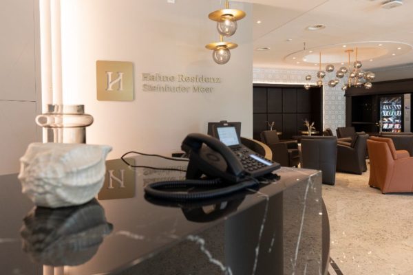 Moderne Rezeption mit freundlicher Atmosphäre, stilvolle Einrichtung und bequeme Lounge-Bereiche in der Hahne Wohnen Residenz Steinhuder Meer.