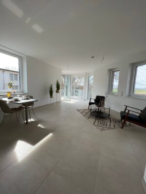 Moderne Wohnzimmereinrichtung mit großen Fenstern, urbanem Design und gemütlichem Sitzbereich, perfekt für stilvolles Wohnen und entspanntes Zuhause.