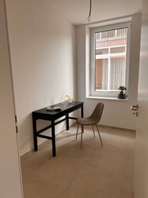 Hahne wohnen kleines Arbeitszimmer mit modernem Design, schwarzem Schreibtisch, bequemer Stuhl und großem Fenster für natürliches Licht. Perfekt für Produktivität und Komfort.