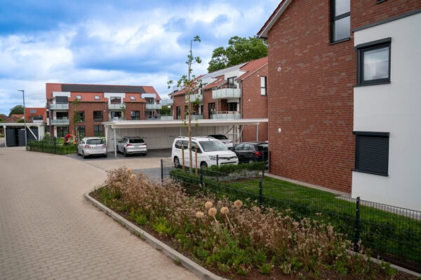 Moderne Mehrfamilienhäuser mit großzügigem Parkplatz und begrüntem Vorgarten in einer ruhigen Wohngegend. Ideal für Familien und Singles, die komfortables Wohnen in attraktiver Lage suchen.